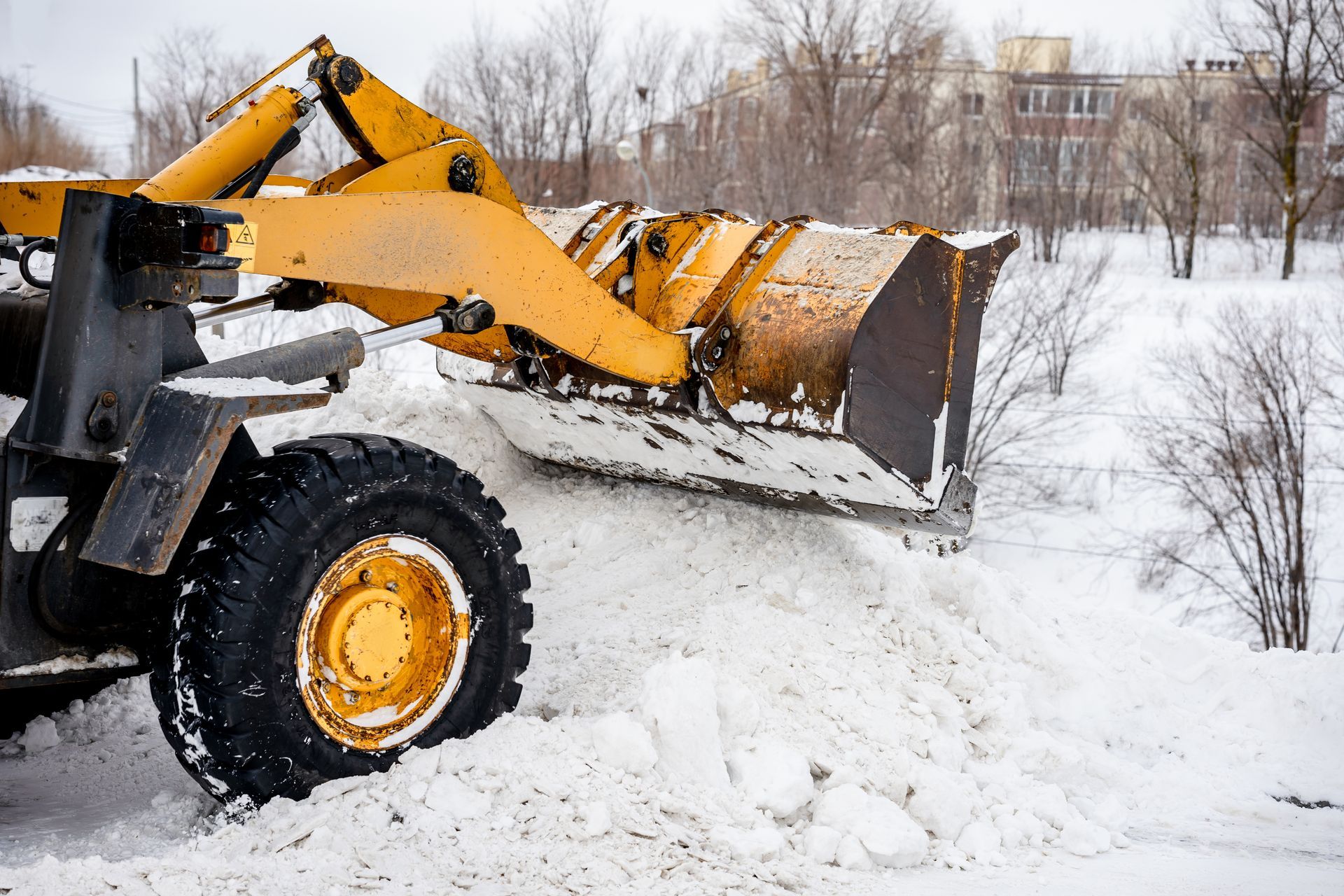 Yellow snowplow clearing snow. Winter scene.