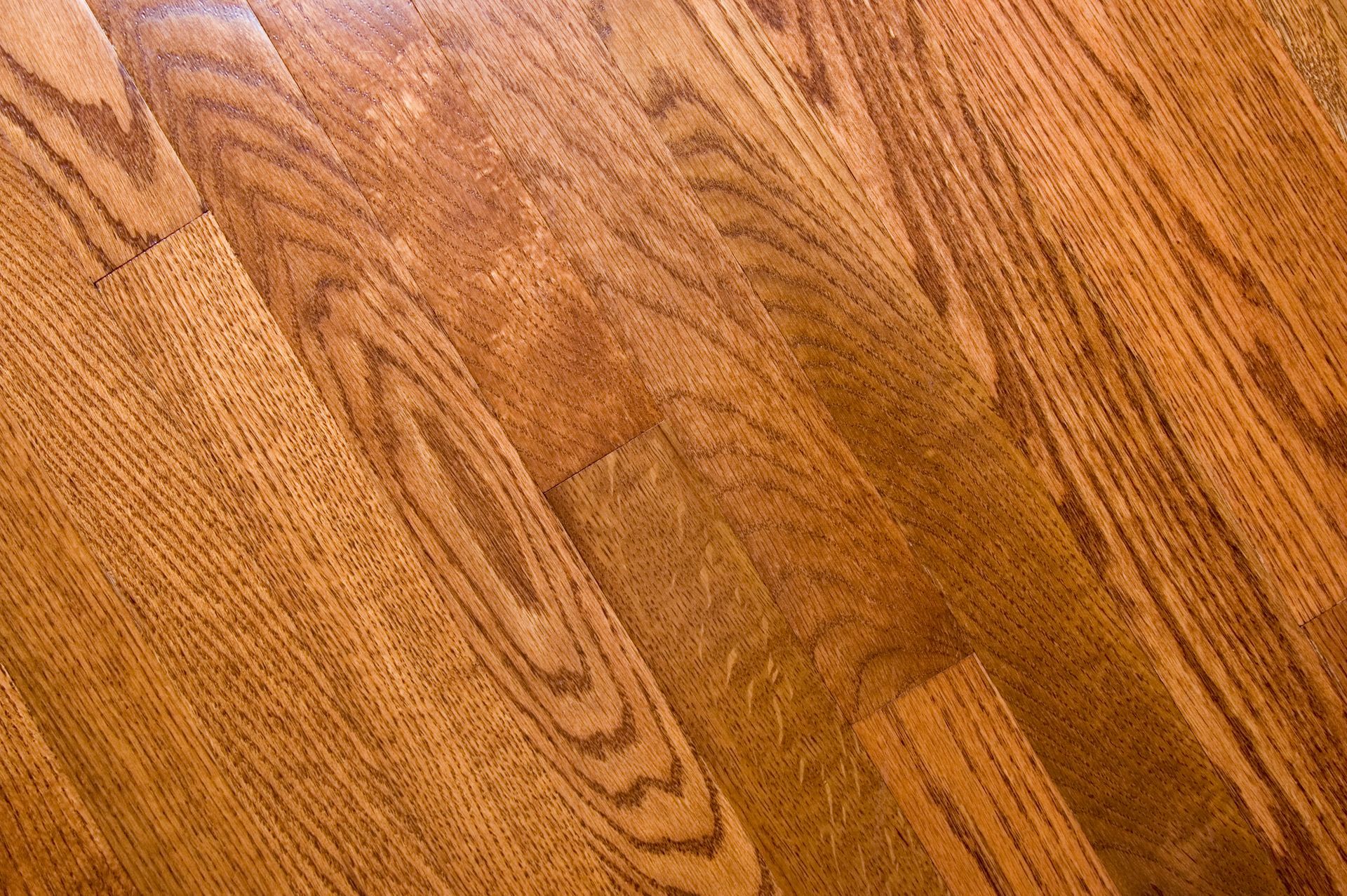 A person is holding a swatch of wooden flooring.