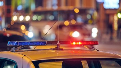 Police car with flashing red and blue lights at night.