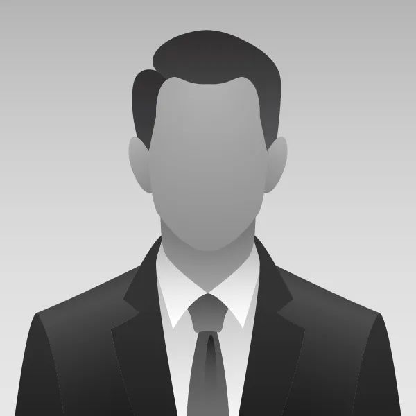 Profile of a person in a suit and tie, against a gray gradient background.