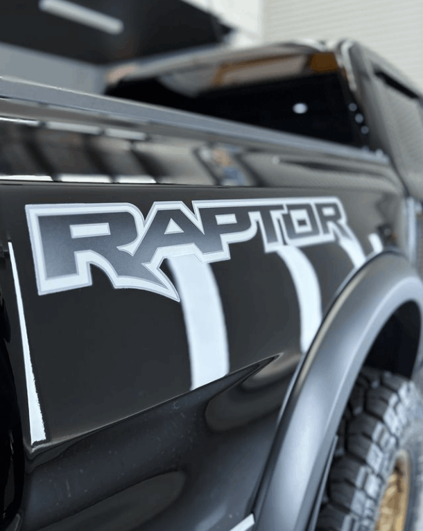 A black raptor truck with white stripes on the side with ceramic coating