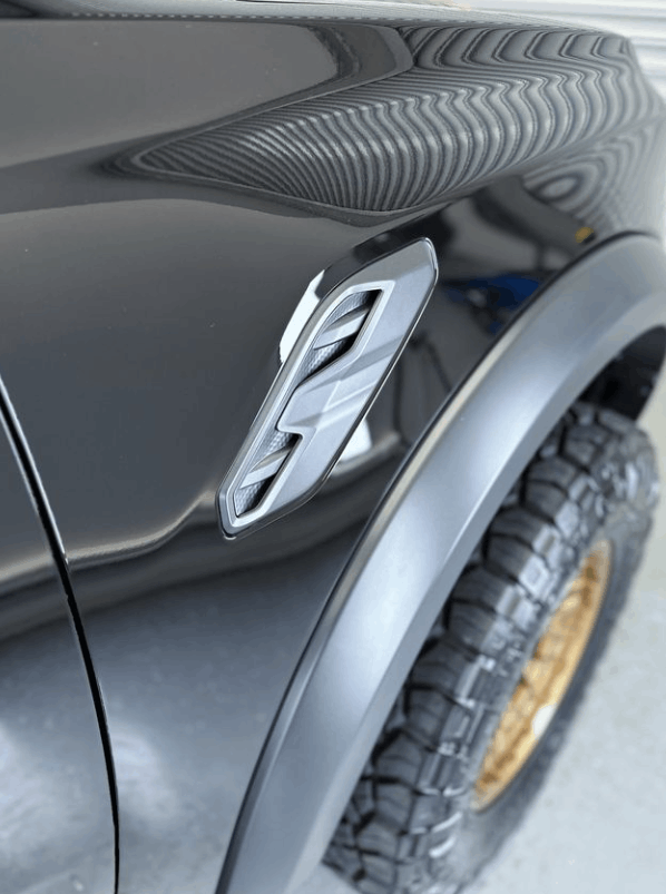 A close up of the fender of a black truck with ceramic coating