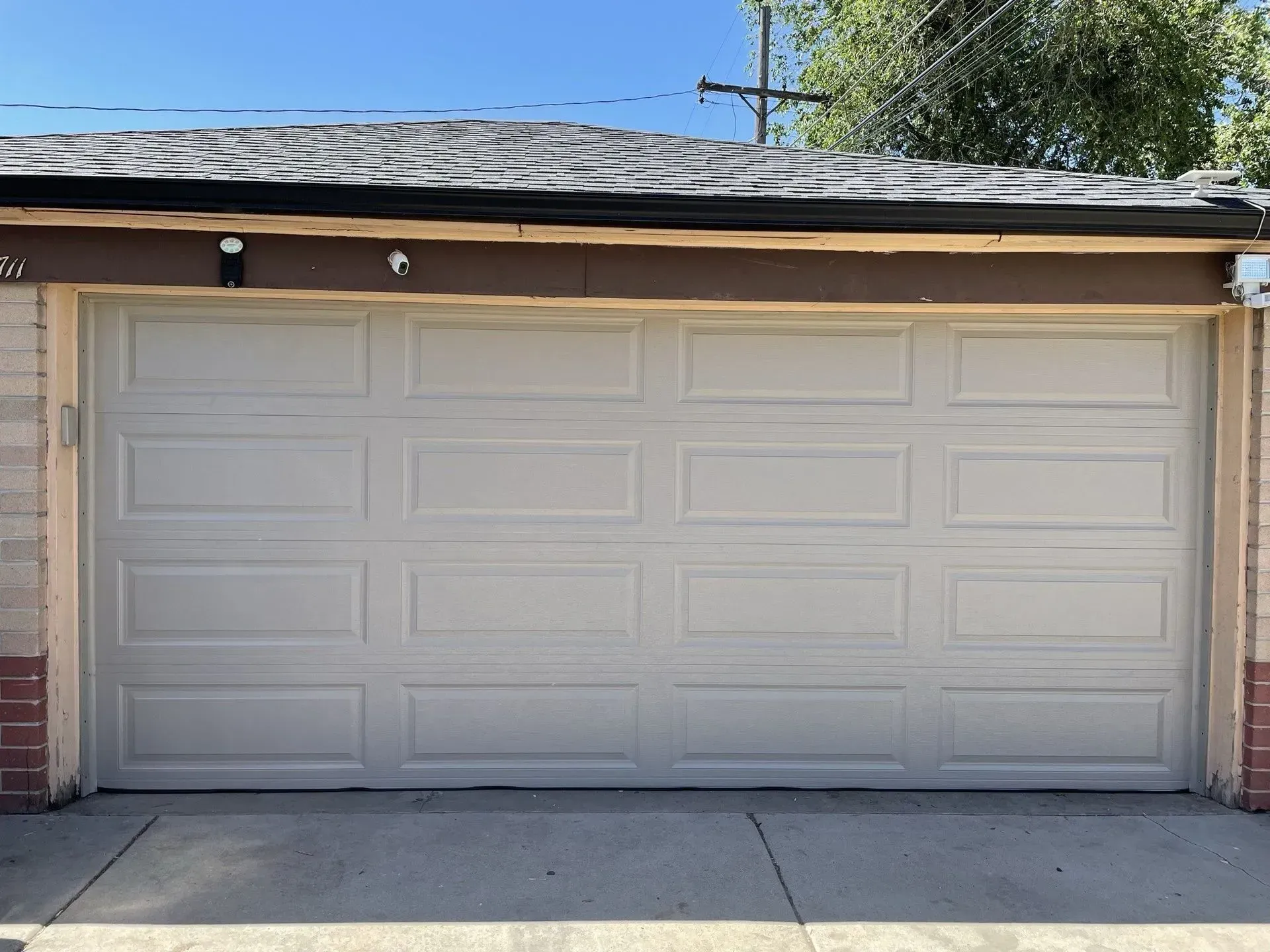 Two-car garage with a white paneled door and gray roof in a residential driveway