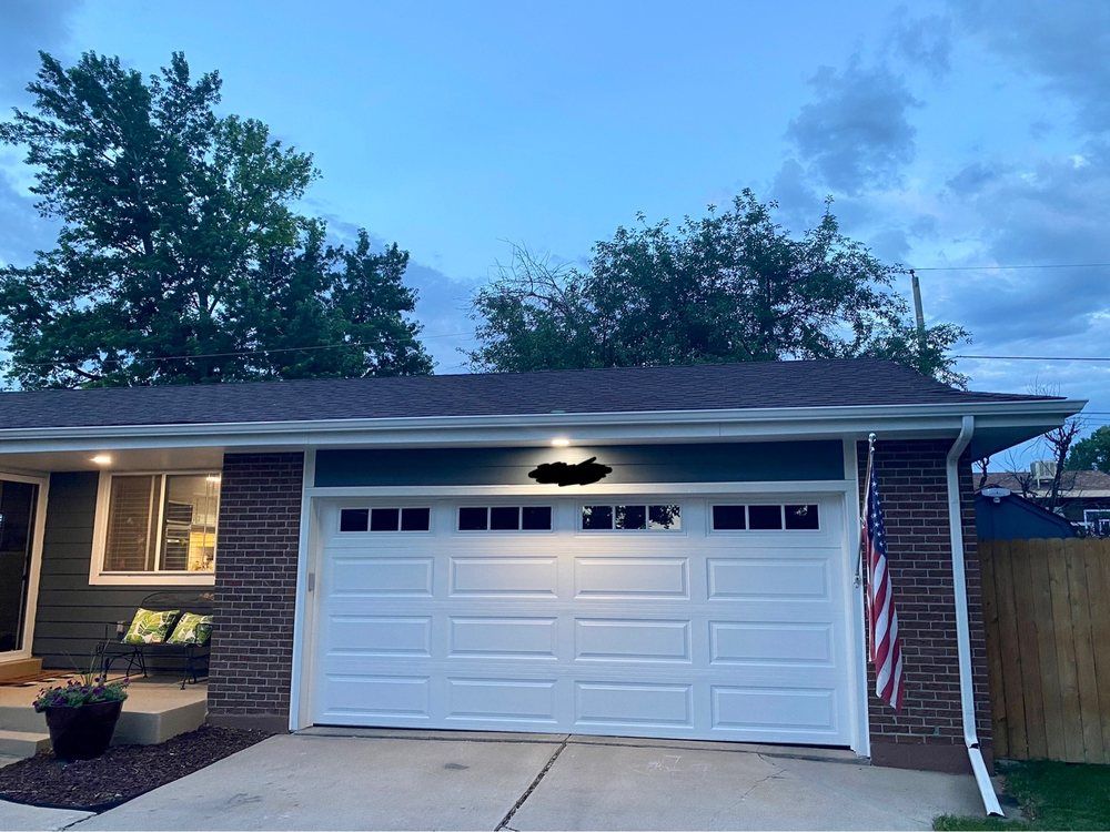 A brick house with a white garage door and an american flag