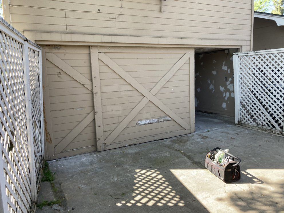 A sliding garage door with a planter in front of it