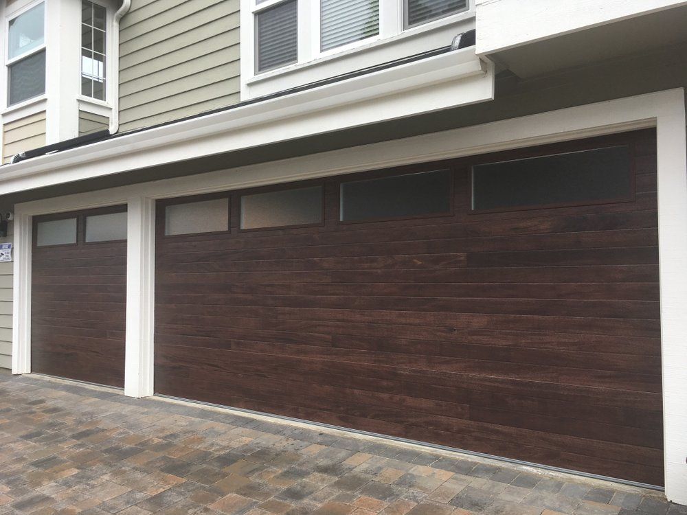 There are two garage doors on the side of a house.
