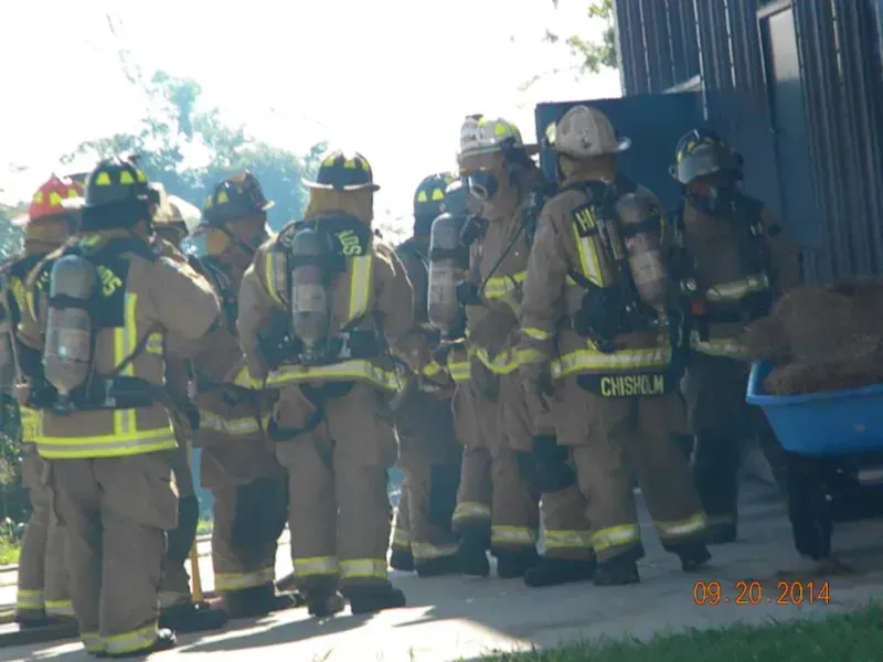 A group of firefighters are standing in a group