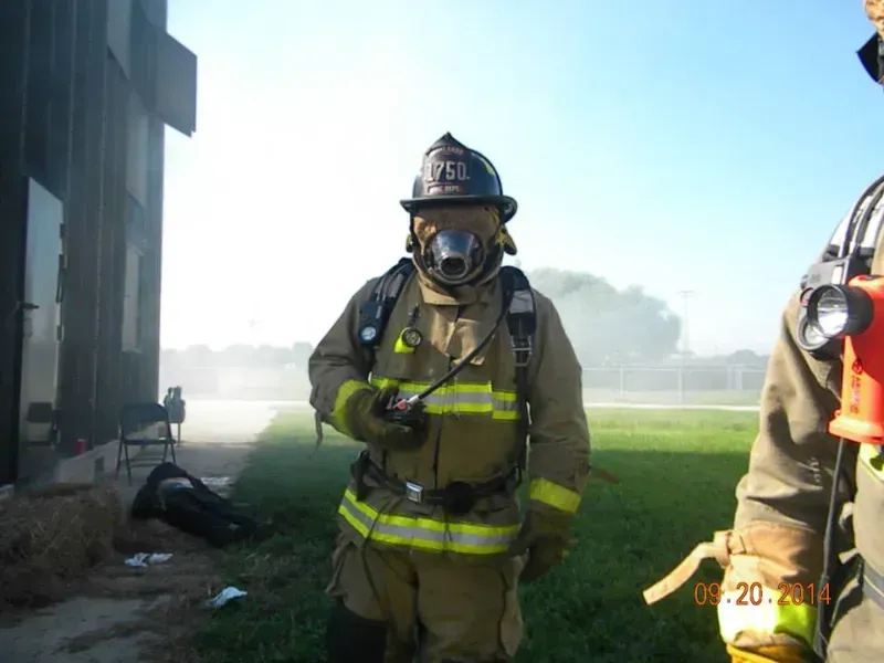 A fireman wearing full fire protective ensemble during a training exercise.