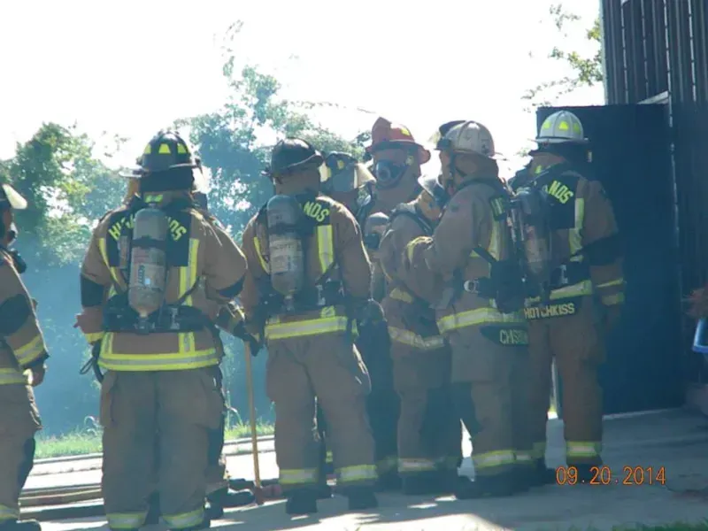 A group of firefighters are standing in a line.