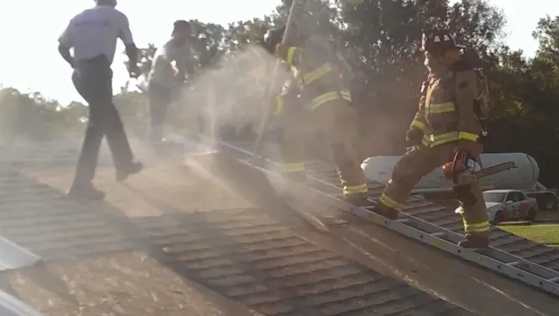 A group of firefighters are spraying water on a train track.