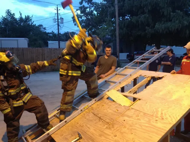 A group of firefighters are working on a roof