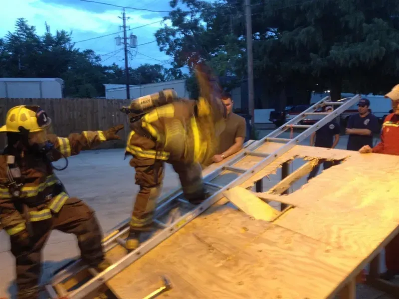 A group of firefighters are working on a ladder