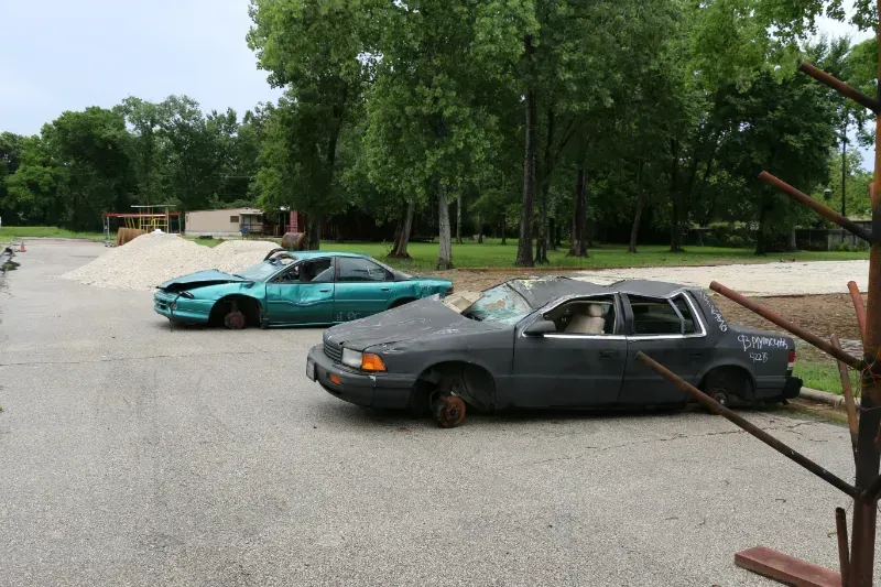 Two cars are parked next to each other in a parking lot.