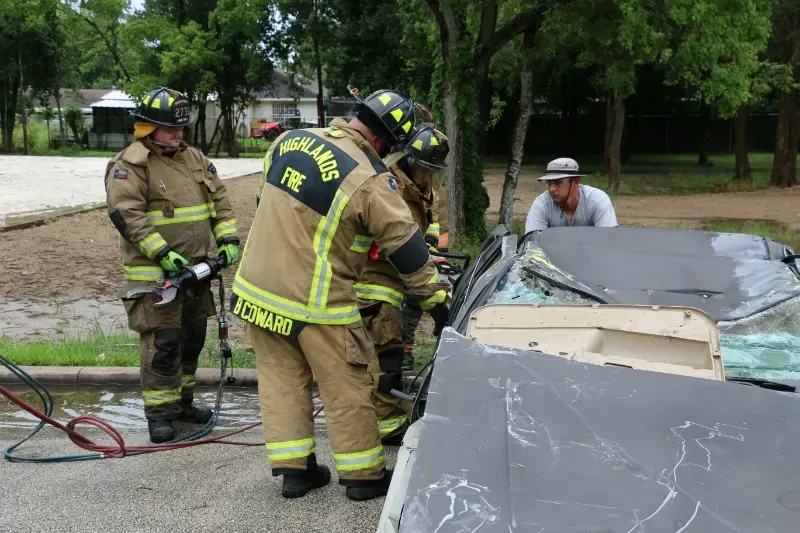 A group of firefighters are working on a car.