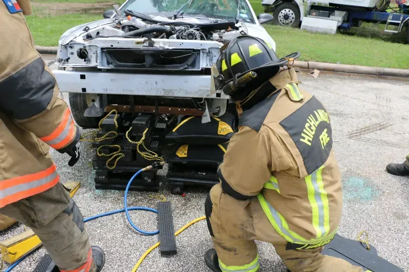 A group of firefighters are working on a staged wrecked car during an extrication exercise.