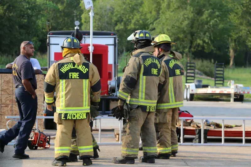 A group of firefighters are standing next to each other during a training exercise.