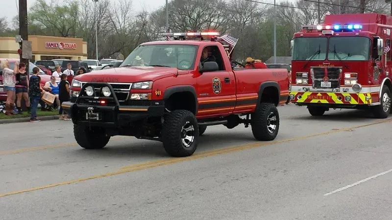 Highlands Fire Department vehicles are driving down a street during a parade