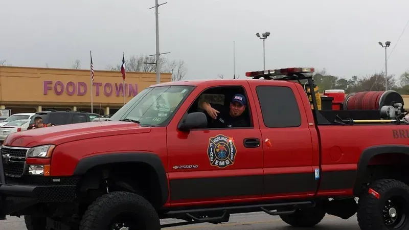 A red Highlands fire department truck is driving in a parade line.