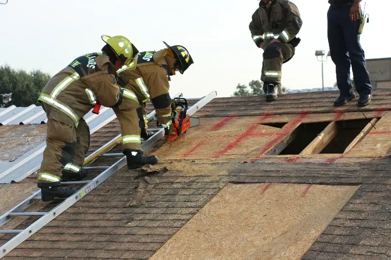 A group of firefighters are training on venting a roof