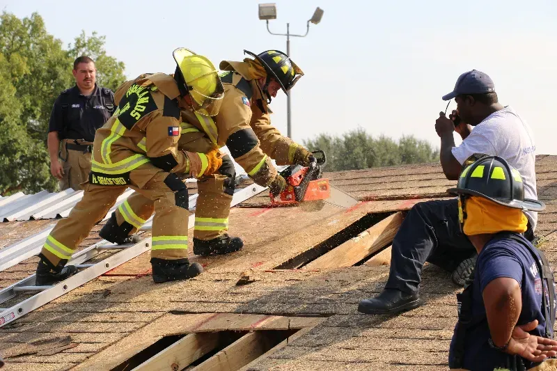 A group of firefighters are training on venting a roof
