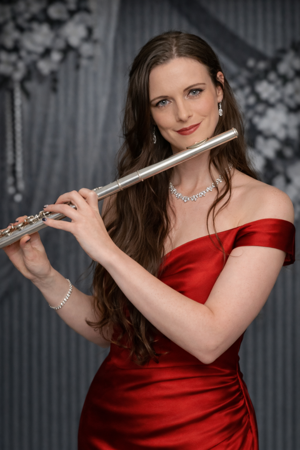 Woman in a red dress holding a flute against a gray studio backdrop