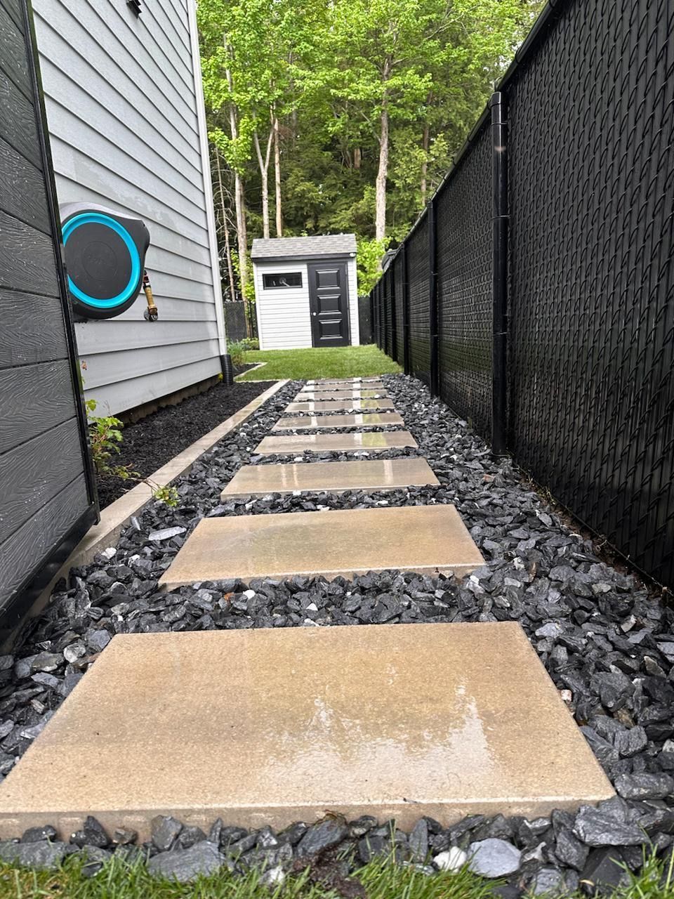 Une allée en pierre menant à un hangar dans une cour arrière.