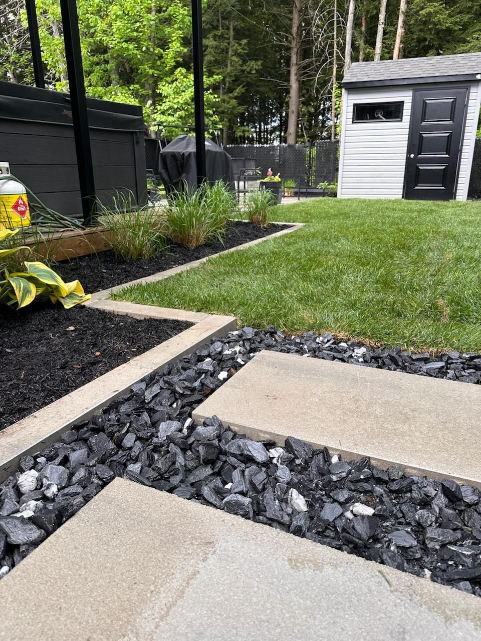 Une cour arrière avec un hangar et une pelouse.