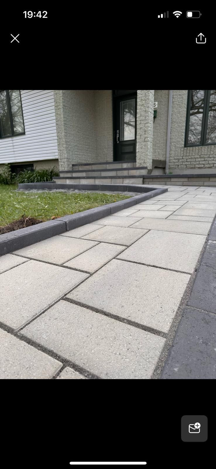 Une photo d'une allée en briques menant à une maison.