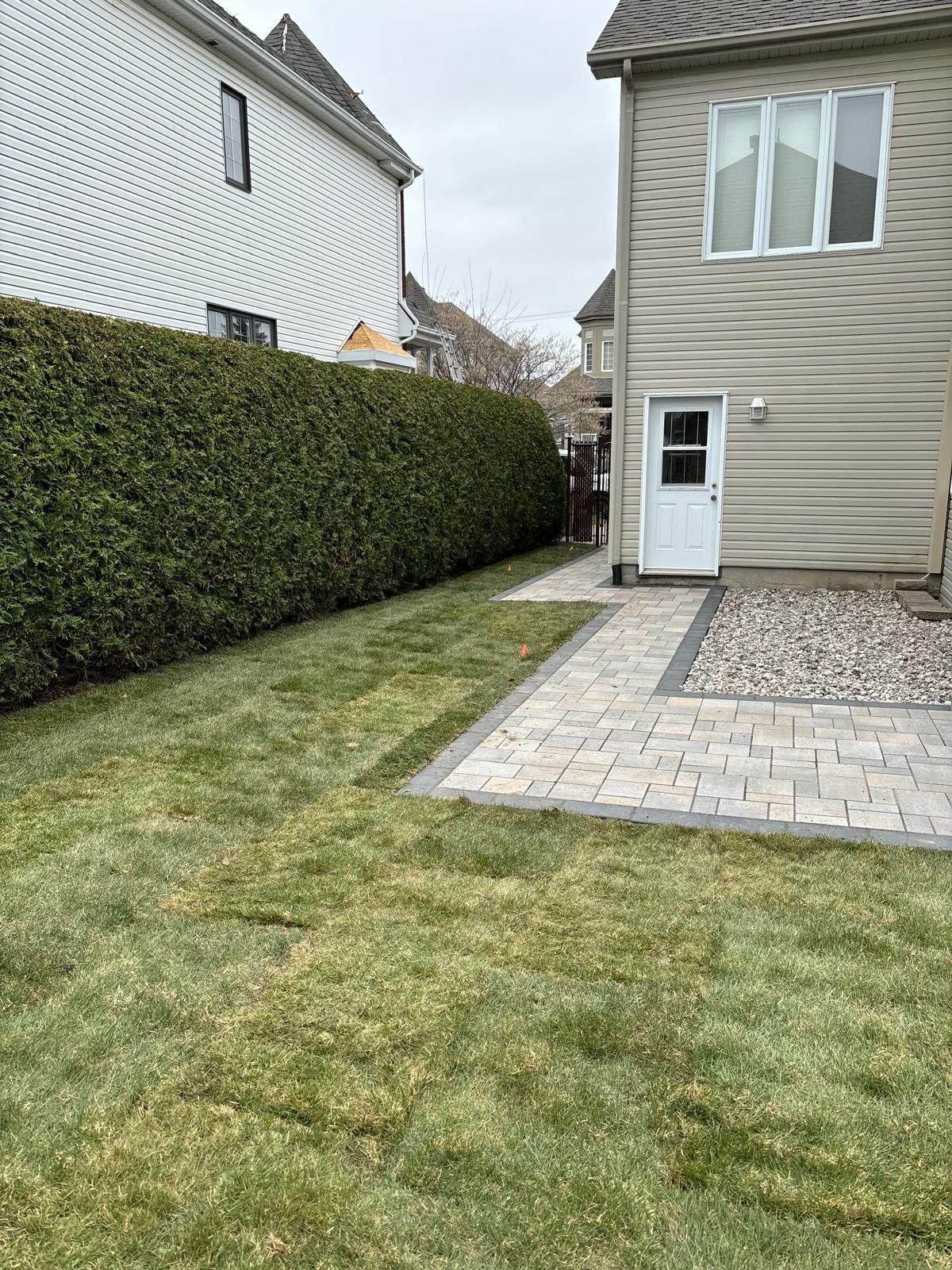 Une cour arrière avec un patio et une maison en arrière-plan.