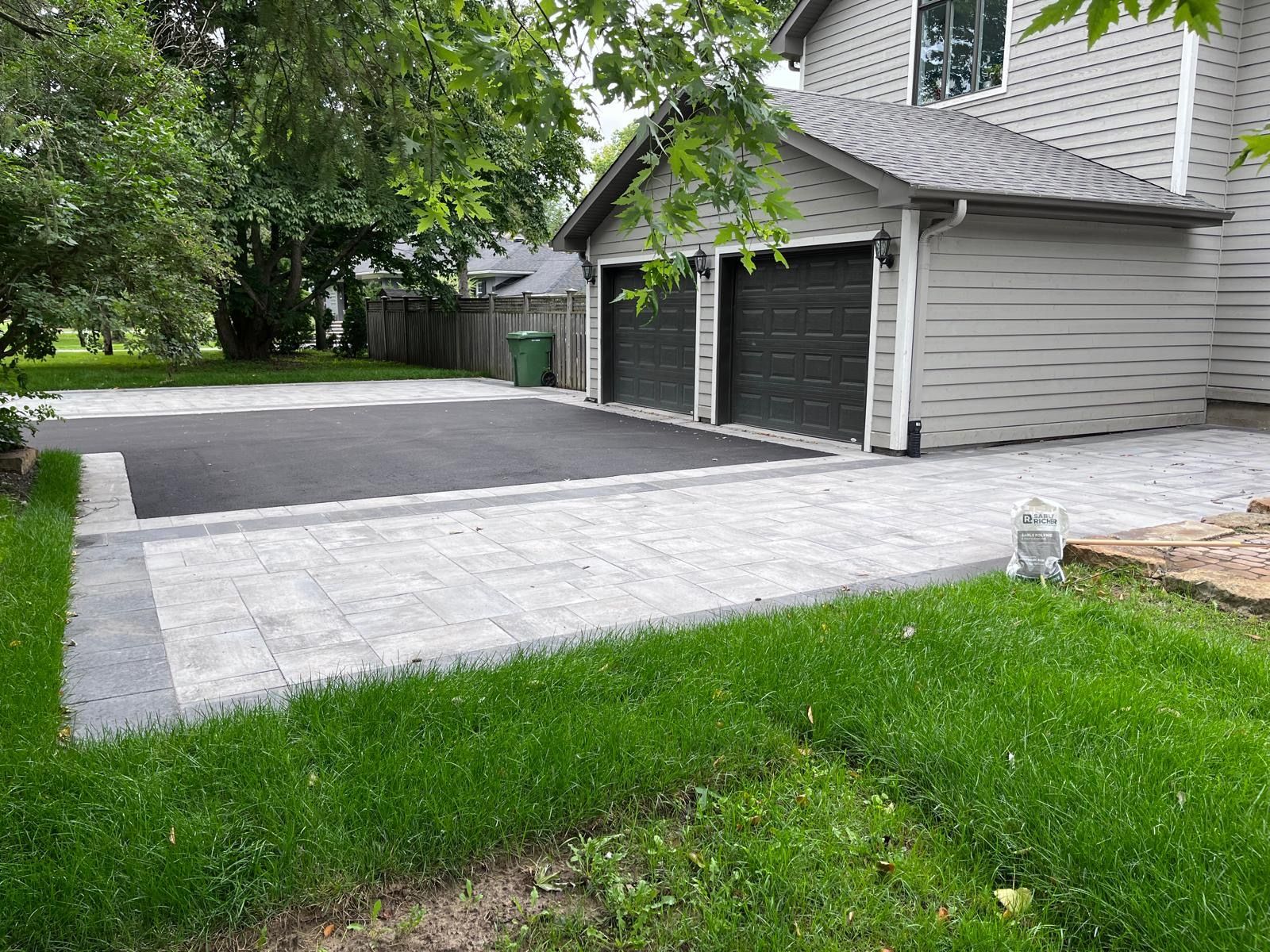 Une maison avec deux garages et une allée devant.