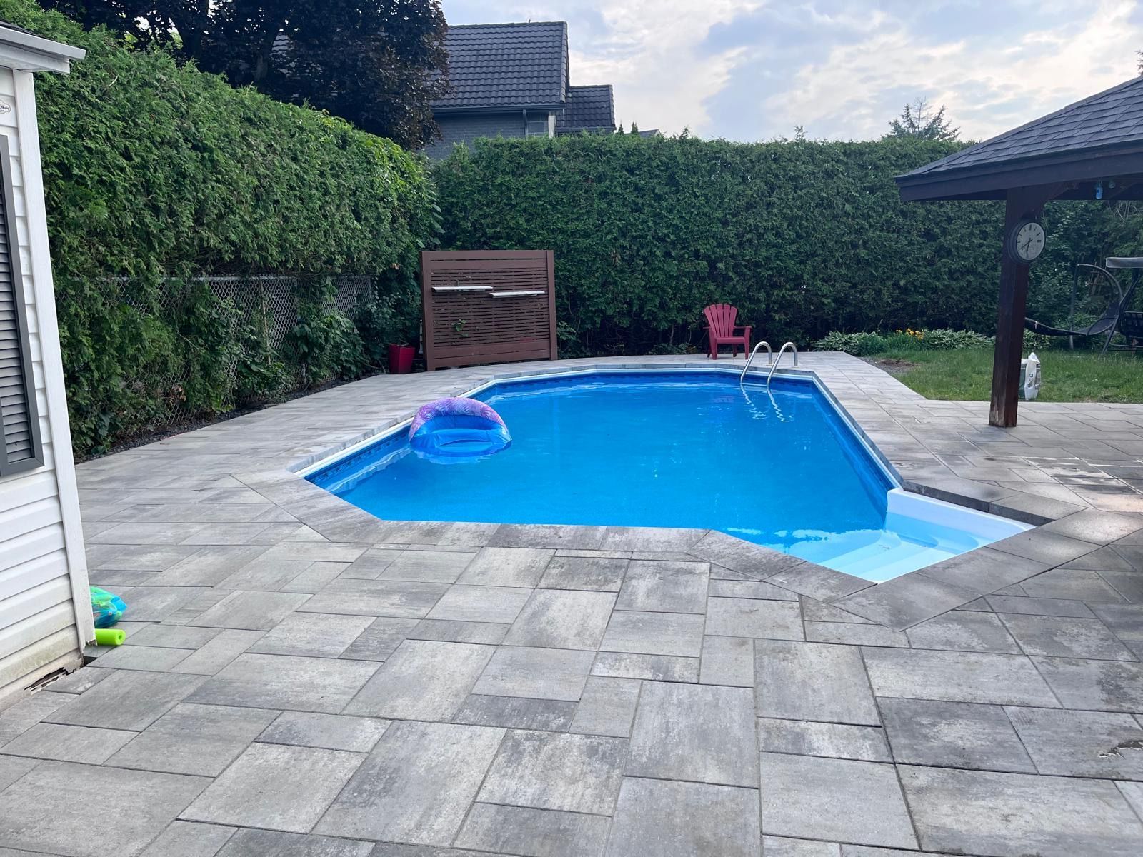 Une grande piscine se trouve dans l'arrière-cour d'une maison.
