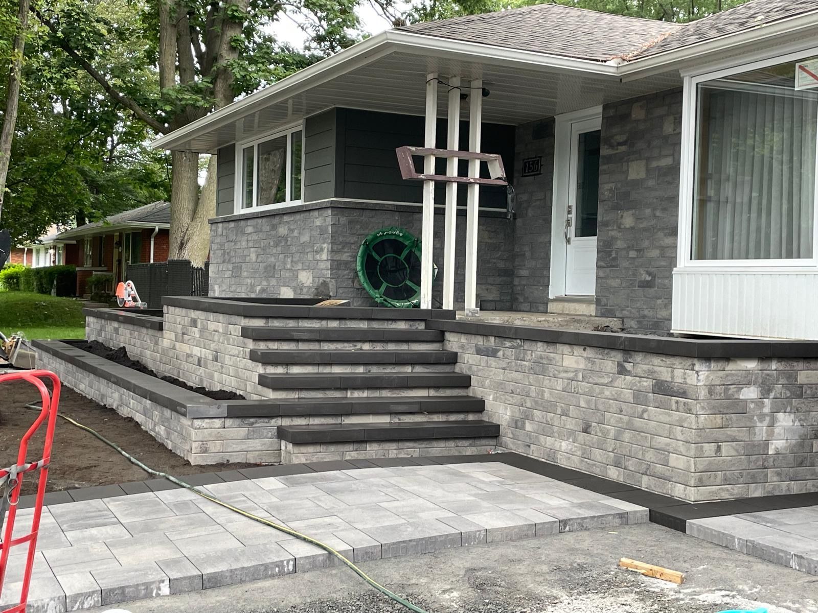 Une maison avec un mur de pierre et des escaliers devant.