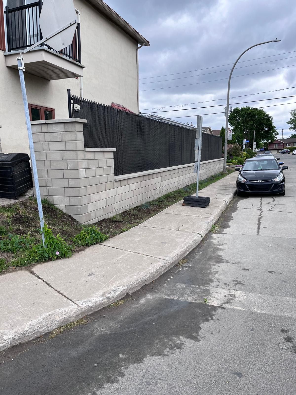 Une voiture est garée sur le bord de la route devant une maison