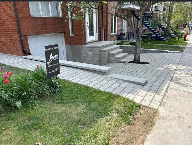 Une maison en briques avec des escaliers et un panneau devant.