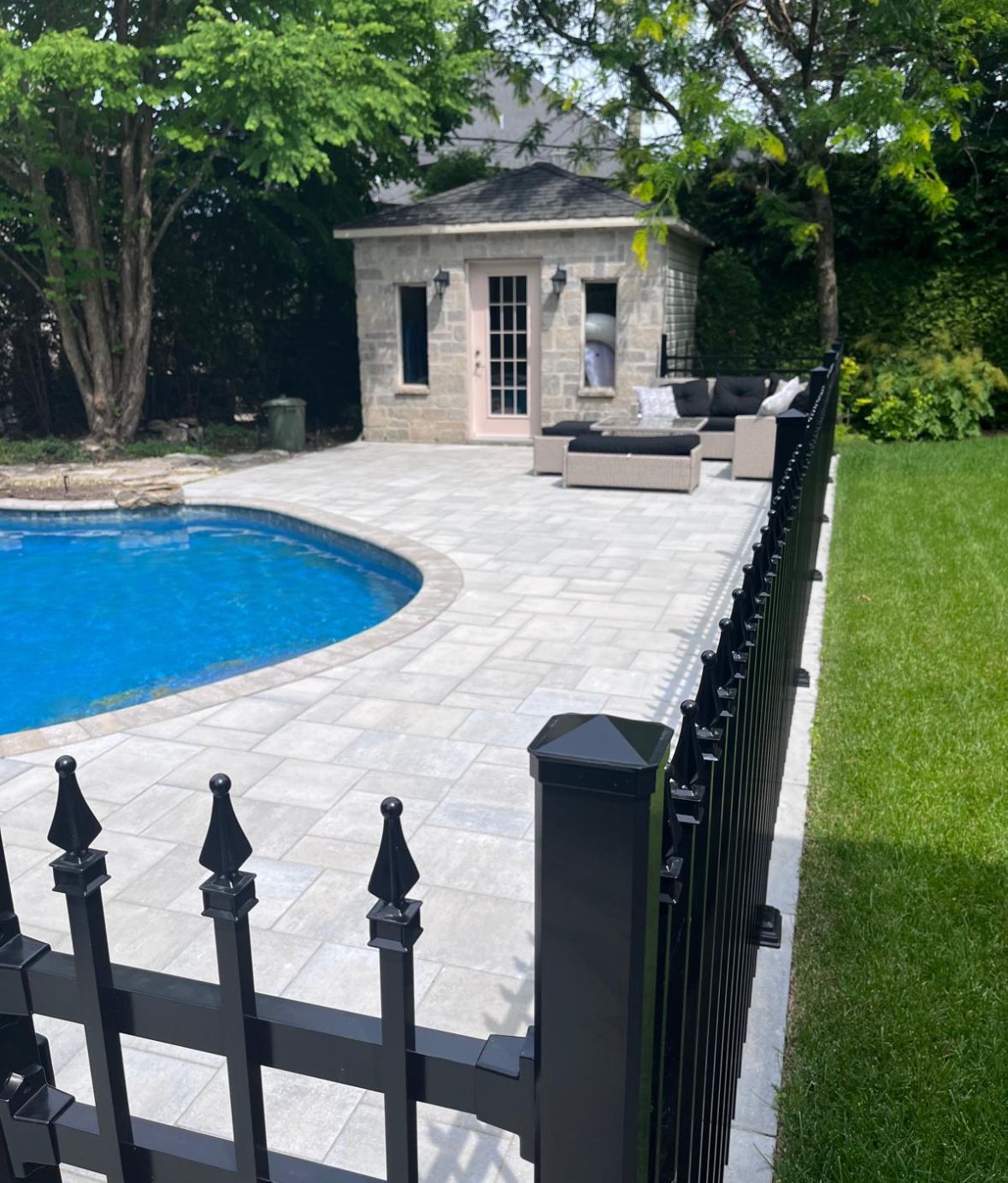 Une clôture entoure une piscine dans une cour arrière