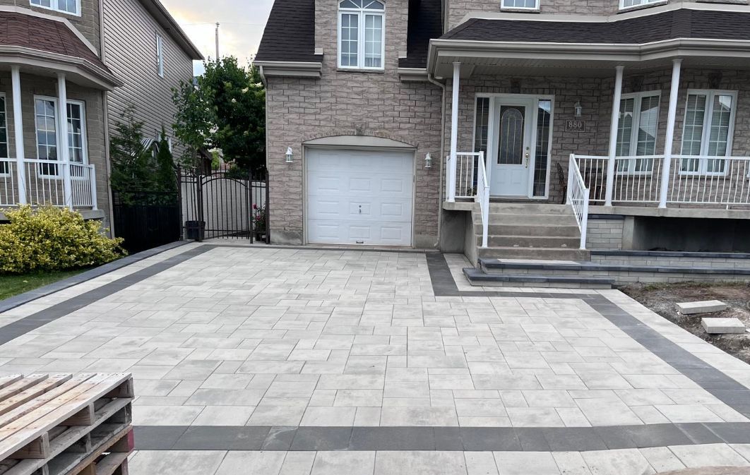 Une grande maison en briques avec une grande allée devant elle.