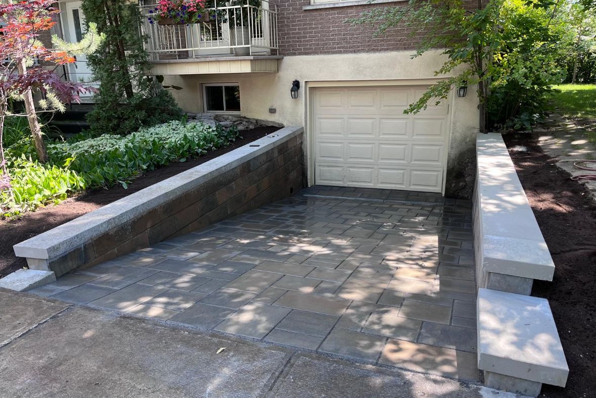 Une allée avec une rampe menant à une porte de garage.