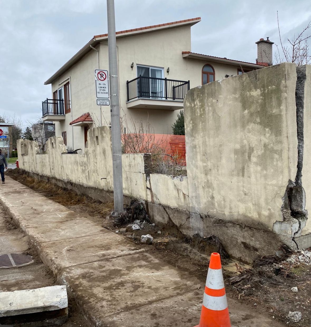 Un panneau d'interdiction de stationnement est sur un poteau devant une maison