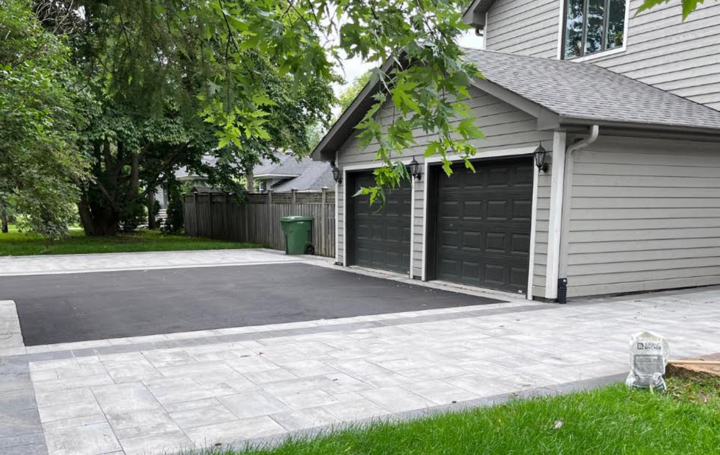Une maison avec deux portes de garage et une allée devant.