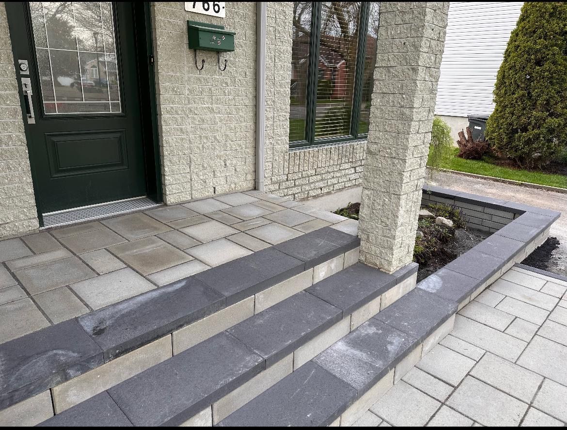 Un porche avec des marches menant à une porte et une boîte aux lettres.