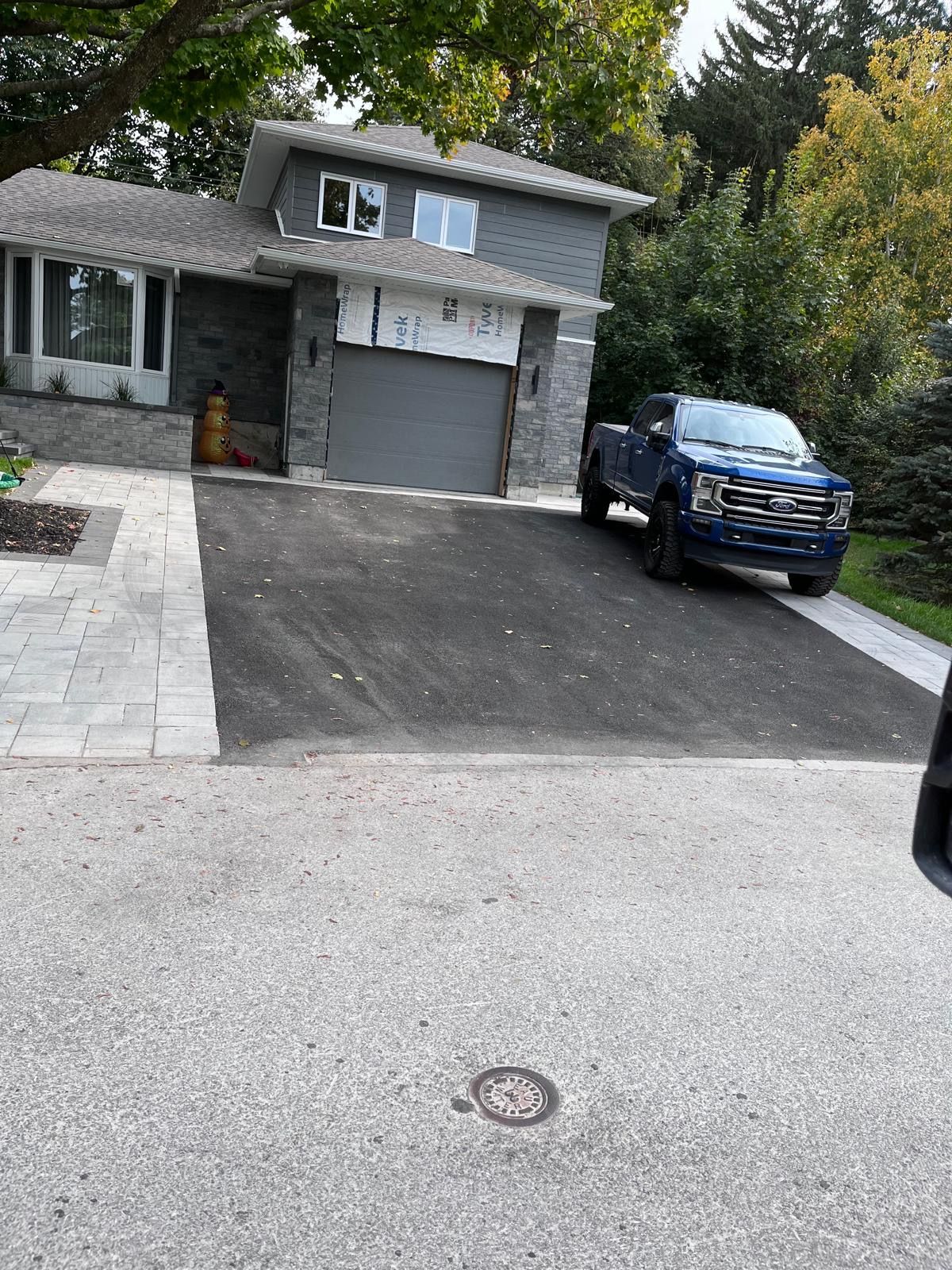 Un camion bleu est garé devant une maison.