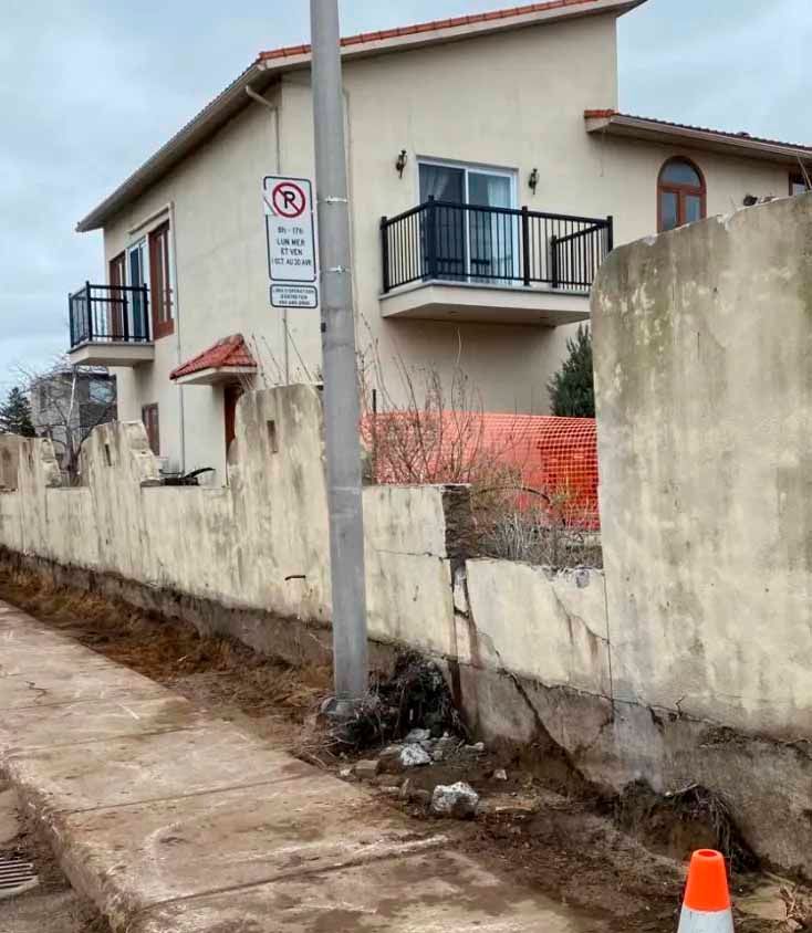 Un panneau d'interdiction de stationnement est sur un poteau devant une maison