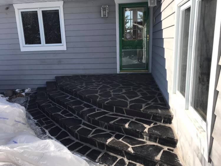 A stone walkway leading to the front door of a house.
