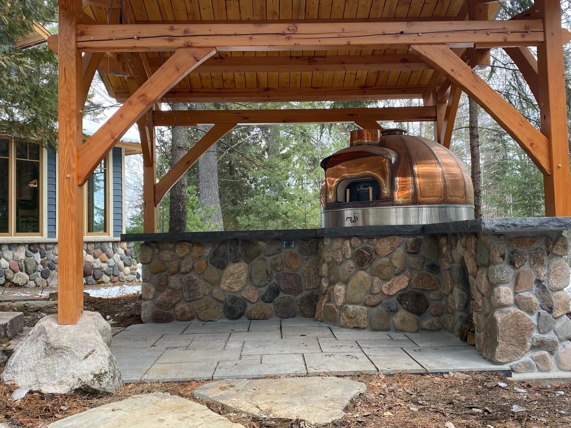 A wooden structure with a pizza oven underneath it