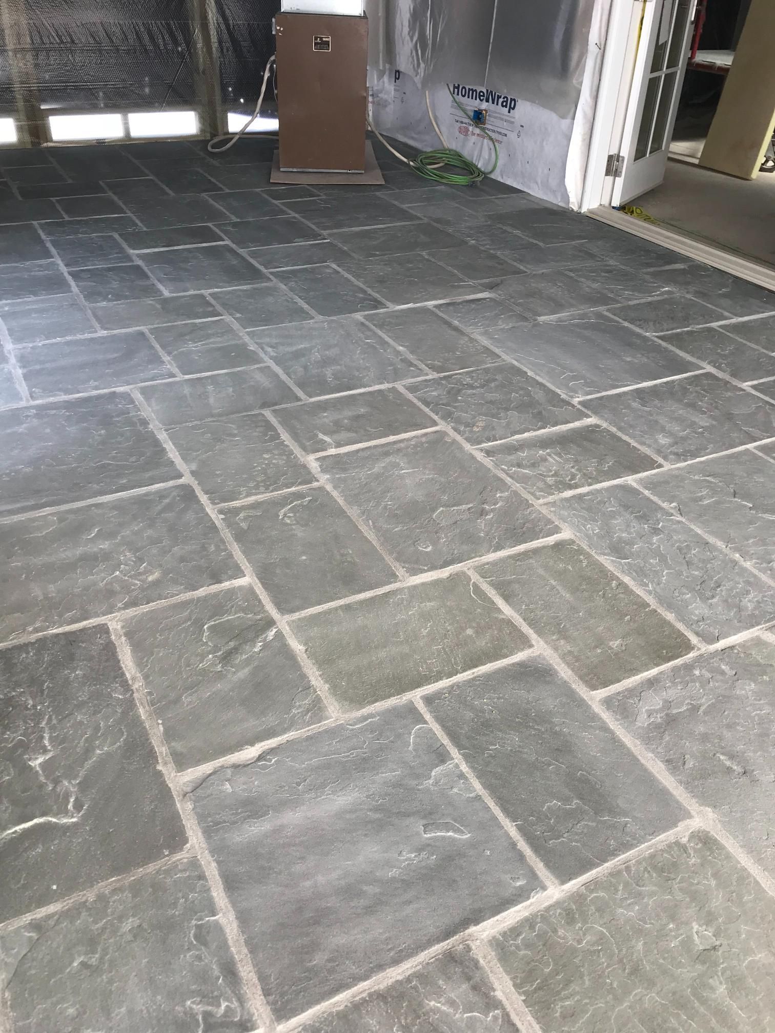 A close up of a tiled floor with a door in the background.