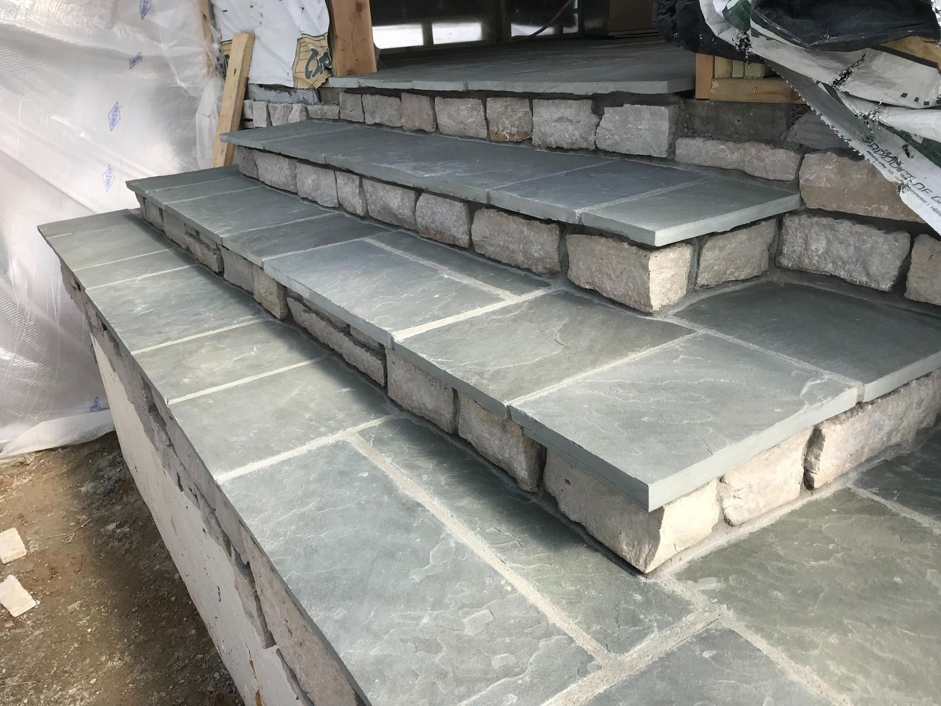 A set of stone stairs being built on a porch.