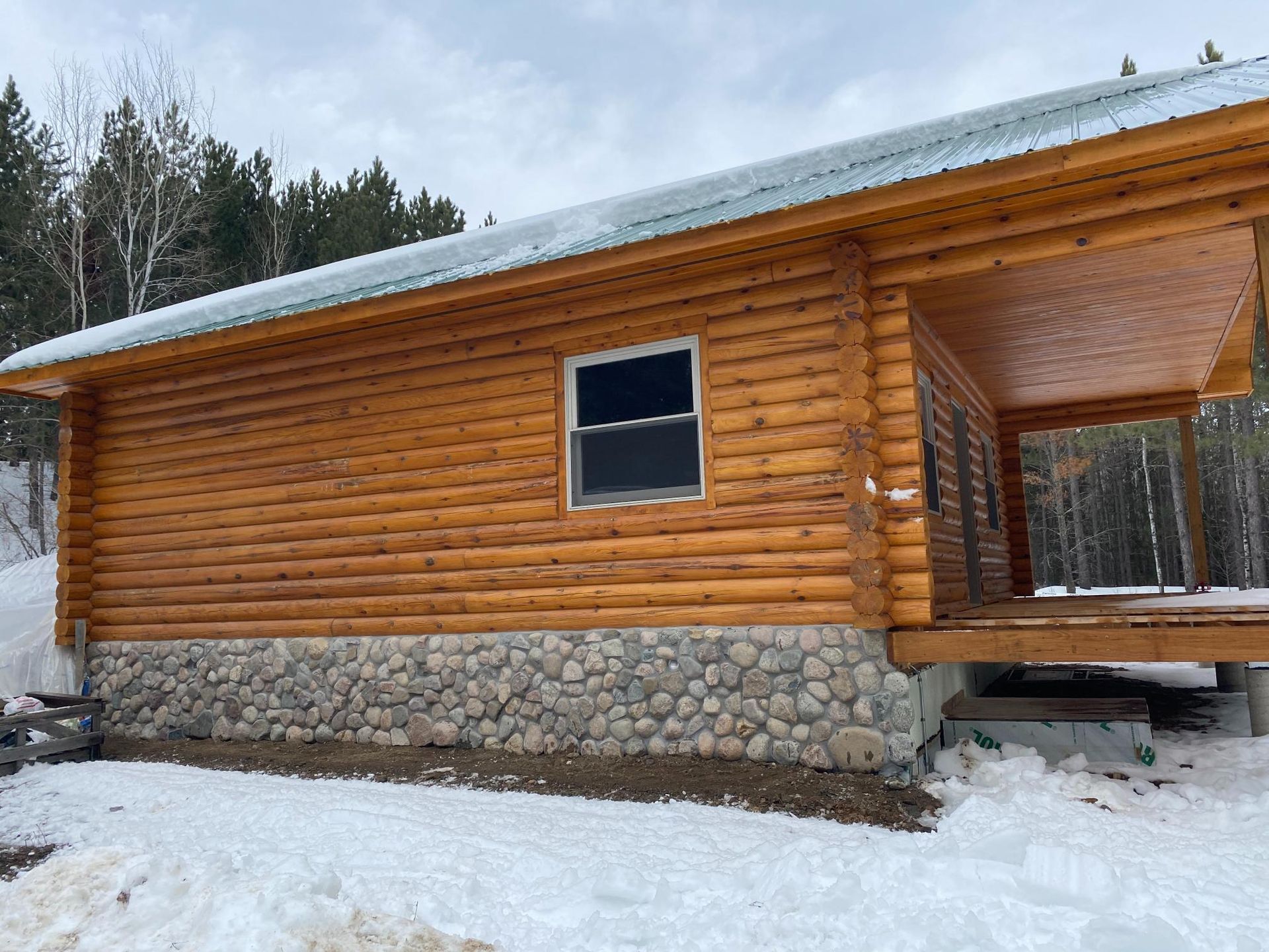 A log cabin is sitting in the middle of a snowy forest.