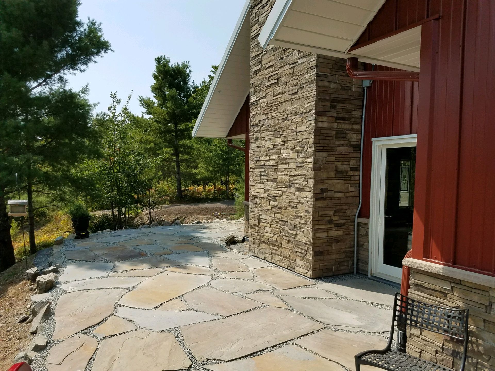 A red house with a stone patio in front of it.
