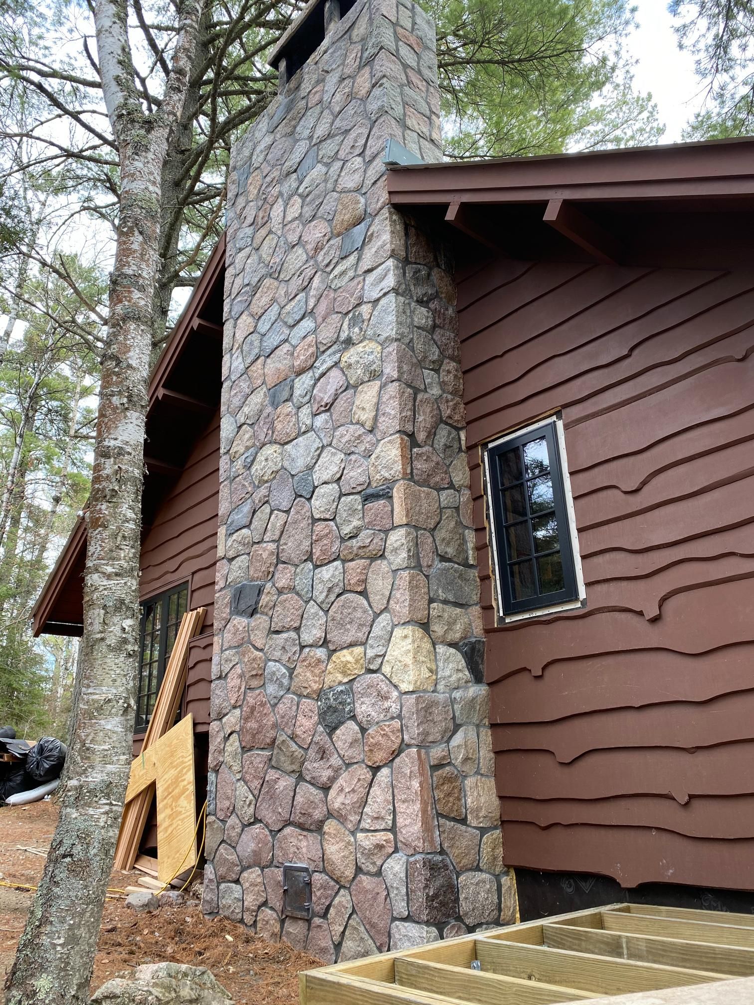 A house with a stone chimney on the side of it.