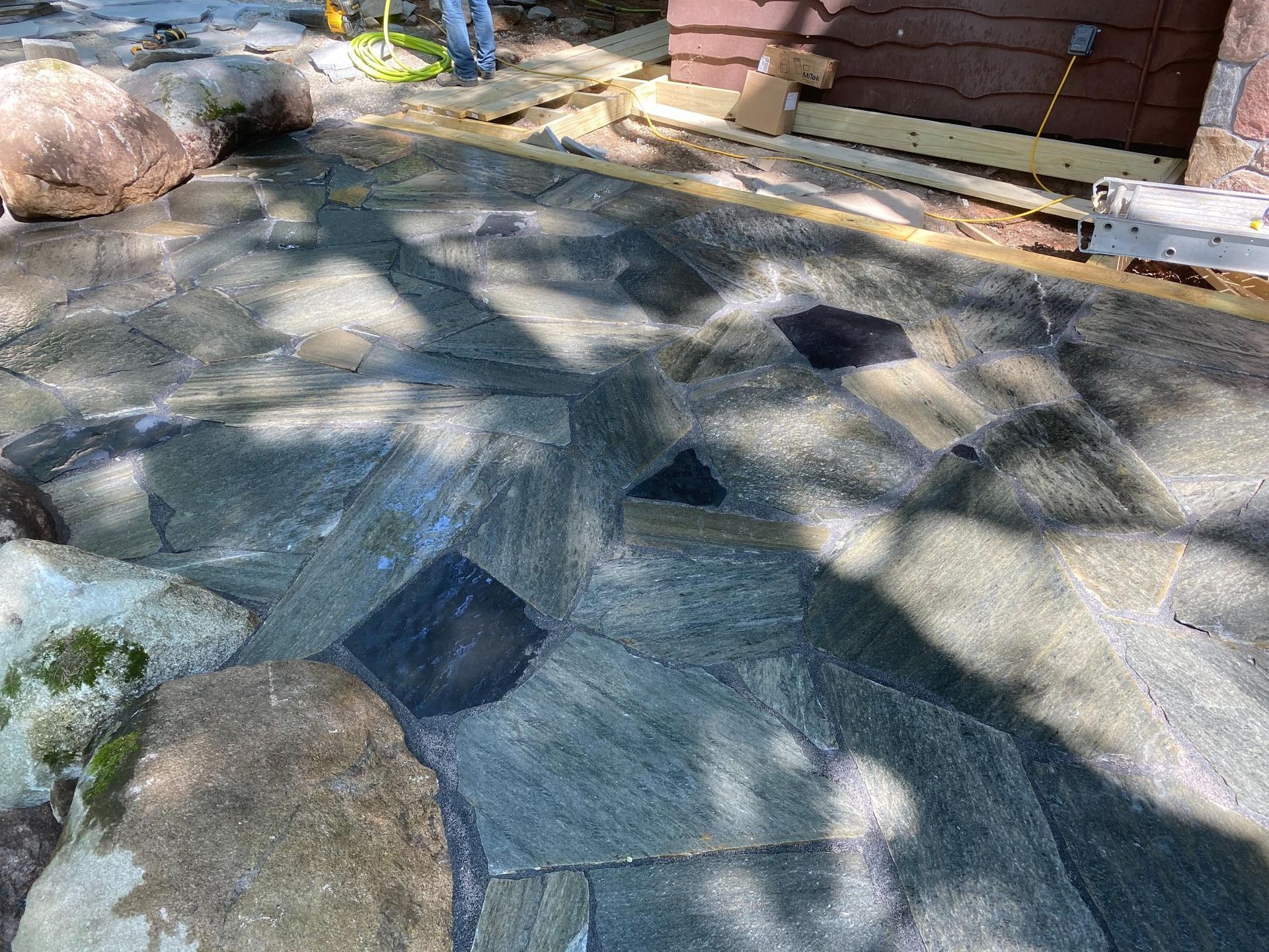 A stone walkway is being built in front of a house.